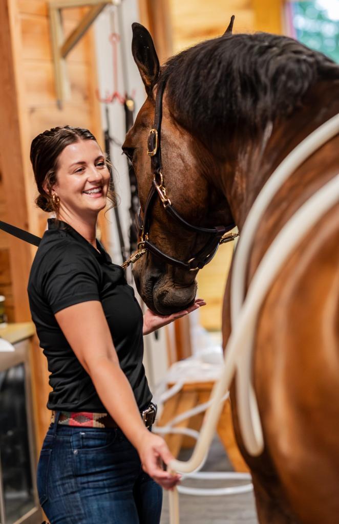 A woman providing PEMF therapy to her horse's back. Picture used by MagnaWavePEMF